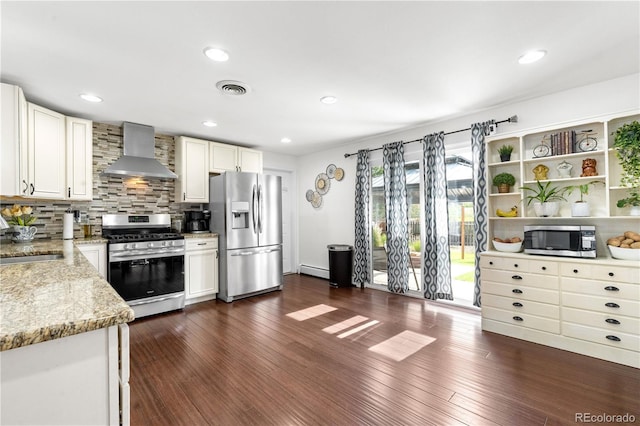 7132 Xavier Way, Westminster, CO 80030 - kitchen featuring wall chimney exhaust hood, appliances with stainless steel finishes, light stone counters, white cabinets, and recessed lighting