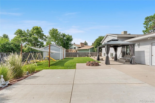 7132 Xavier Way, Westminster, CO 80030 - fenced backyard featuring a patio area, an outdoor fire pit, a playground, a gazebo, and a storage unit