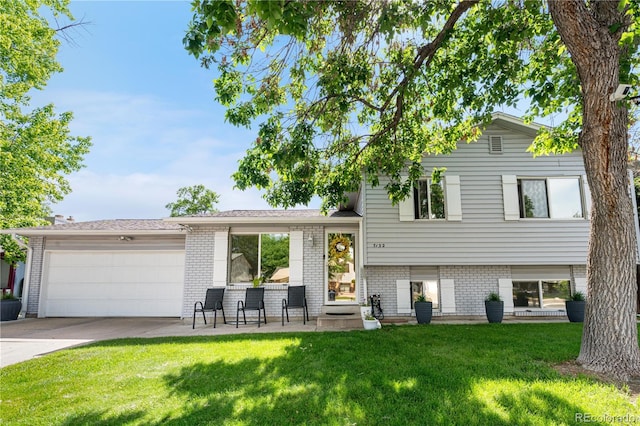 7132 Xavier Way, Westminster, CO 80030 - split level home featuring a front yard, a garage, driveway, and brick siding