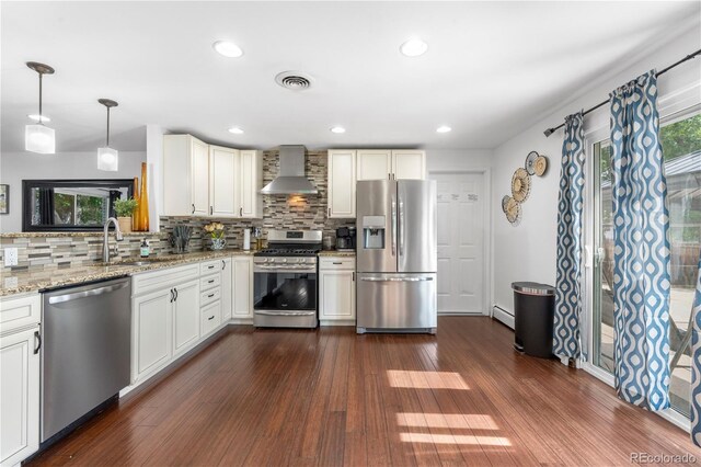 7132 Xavier Way, Westminster, CO 80030 - kitchen with appliances with stainless steel finishes, wall chimney range hood, baseboard heating, tasteful backsplash, and recessed lighting
