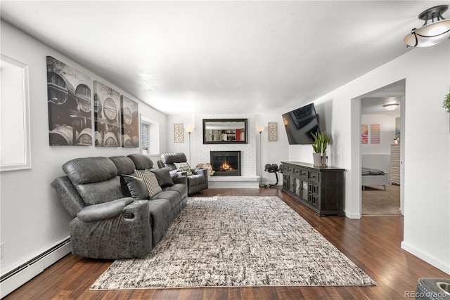 7132 Xavier Way, Westminster, CO 80030 - living room featuring a baseboard heating unit, a brick fireplace, and dark wood-type flooring