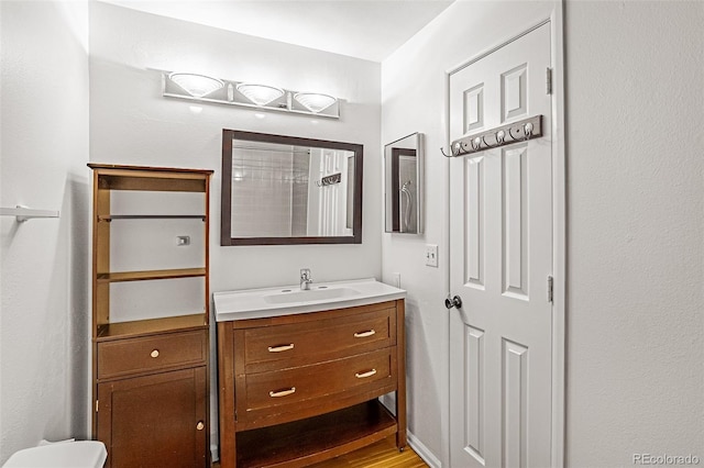 bathroom with wood finished floors and vanity