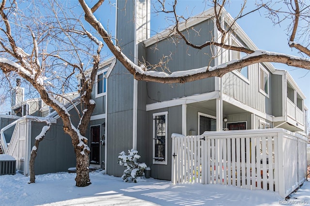 view of front of house with cooling unit and fence