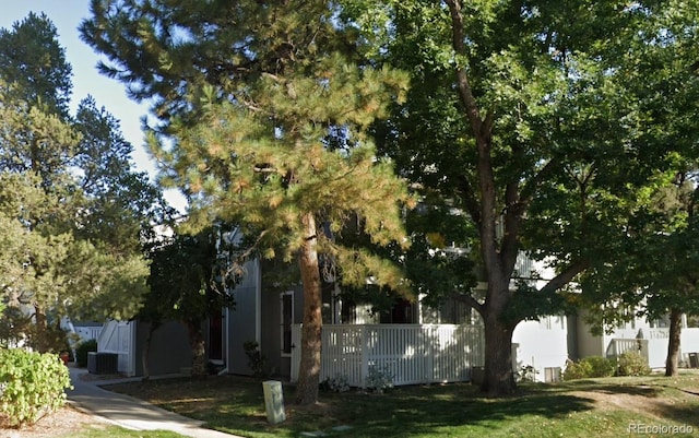 view of side of home with central AC and fence