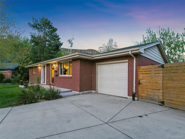 207 Iowa Dr, Golden, CO 80403 - single story home with concrete driveway, a garage, brick siding, and fence