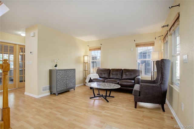 living room with light wood-type flooring and french doors