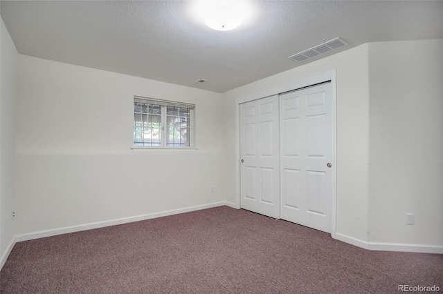 unfurnished bedroom with a closet, carpet, and a textured ceiling