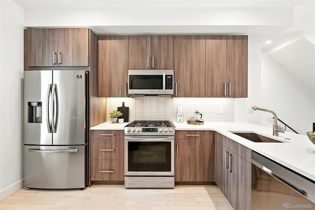 4394 Zenobia St, Denver, CO 80212 - kitchen featuring appliances with stainless steel finishes, light countertops, backsplash, and light wood-type flooring