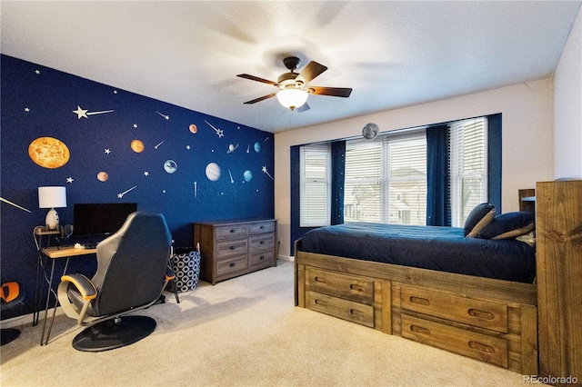 bedroom featuring an accent wall, baseboards, a ceiling fan, and light colored carpet