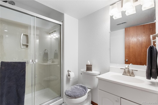 full bathroom with a stall shower, visible vents, a textured wall, toilet, and vanity