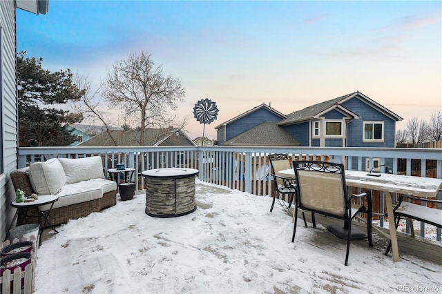 snow covered patio featuring a deck