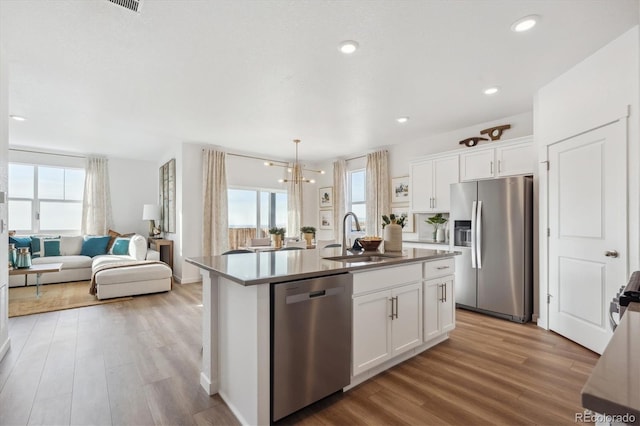 874 Ledge St, Lochbuie, CO 80603 - kitchen featuring appliances with stainless steel finishes, a sink, light wood-style flooring, open floor plan, and recessed lighting