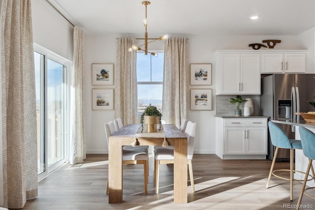 874 Ledge St, Lochbuie, CO 80603 - dining space featuring healthy amount of natural light, a chandelier, light wood-type flooring, recessed lighting, and baseboards