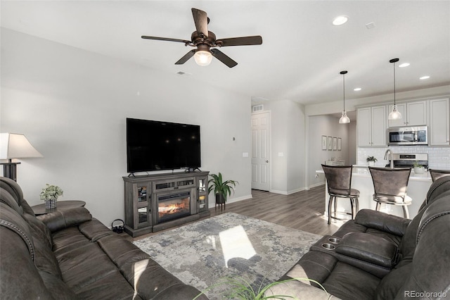 living room featuring light wood-type flooring and ceiling fan