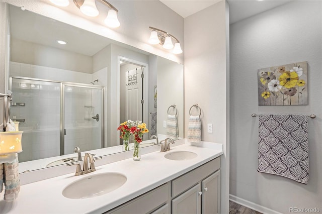 bathroom featuring vanity, wood-type flooring, and a shower with door