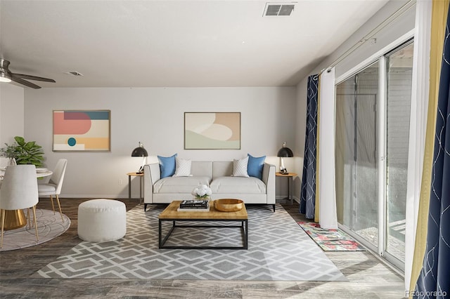 living area with baseboards, ceiling fan, visible vents, and wood finished floors