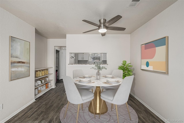 dining room with baseboards, visible vents, ceiling fan, dark wood-style flooring, and a textured ceiling