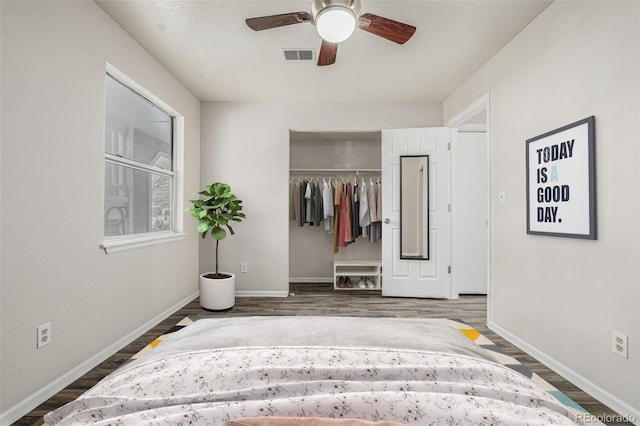 unfurnished bedroom featuring dark wood-style floors, a closet, visible vents, and baseboards