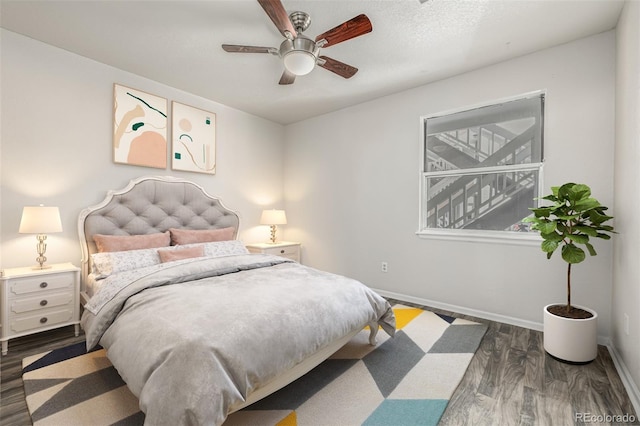 bedroom featuring ceiling fan, baseboards, and dark wood-style flooring