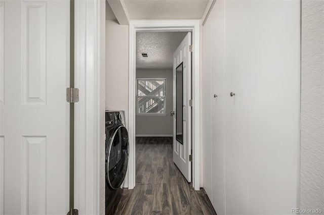 clothes washing area with dark wood-style floors, a textured ceiling, washer / dryer, laundry area, and baseboards