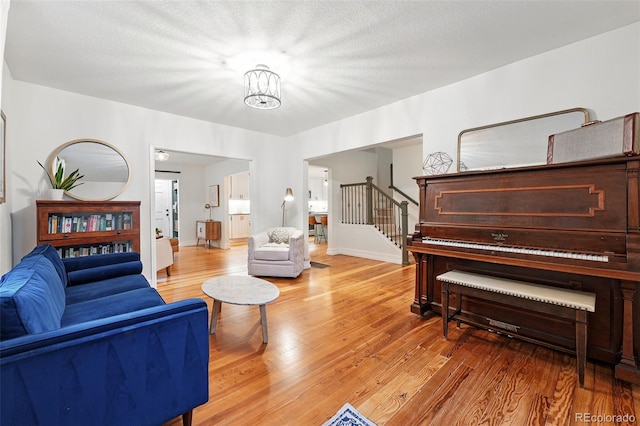 6830 Lamar St, Arvada, CO 80003 - living area featuring stairway, light wood-style flooring, and baseboards