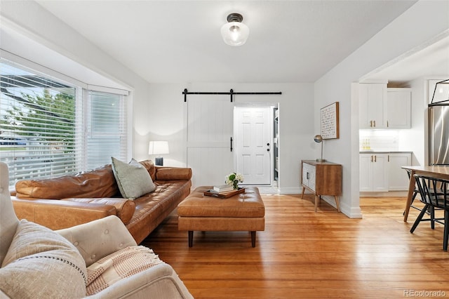 6830 Lamar St, Arvada, CO 80003 - living room featuring light wood-style floors, a barn door, and baseboards