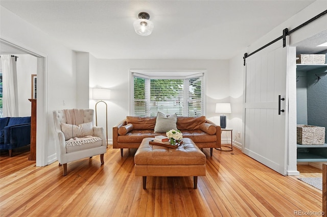 6830 Lamar St, Arvada, CO 80003 - living room featuring a barn door, light wood-style flooring, and baseboards