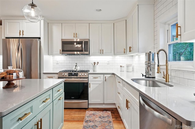 6830 Lamar St, Arvada, CO 80003 - kitchen featuring stainless steel appliances, a sink, white cabinets, and recessed lighting