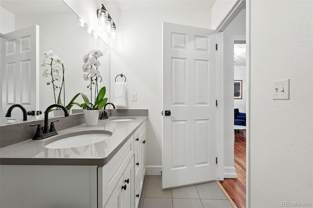 6830 Lamar St, Arvada, CO 80003 - ensuite bathroom featuring tile patterned floors, double vanity, and baseboards