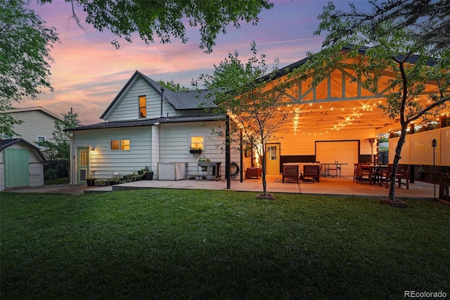 6830 Lamar St, Arvada, CO 80003 - back of property at dusk featuring a patio area and a lawn