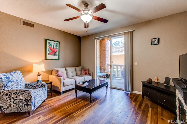 living room featuring baseboards, ceiling fan, visible vents, and wood finished floors