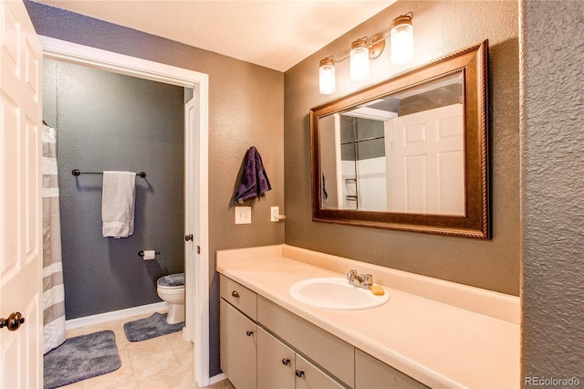 bathroom featuring toilet, tile patterned floors, a textured wall, and vanity