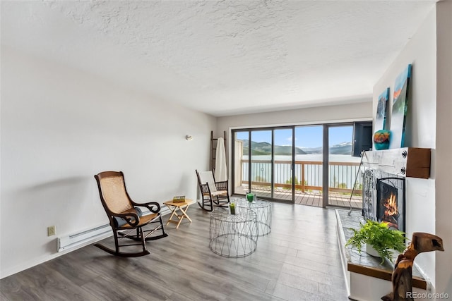 311 W La Bonte St Unit 306, Dillon, CO 80435 - living area featuring a warm lit fireplace, a textured ceiling, wood finished floors, and a water view
