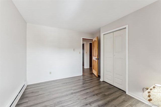 311 W La Bonte St Unit 306, Dillon, CO 80435 - unfurnished bedroom featuring baseboard heating, wood finished floors, a closet, and baseboards