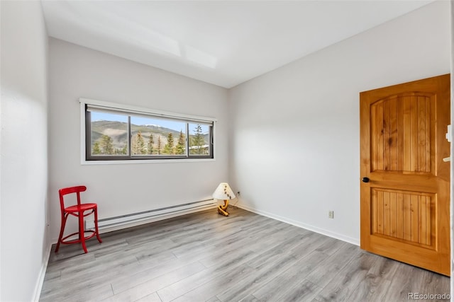 311 W La Bonte St Unit 306, Dillon, CO 80435 - spare room featuring a baseboard heating unit, light wood finished floors, and baseboards