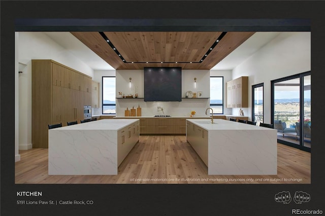 kitchen with a kitchen island with sink, sink, wooden ceiling, and light hardwood / wood-style floors