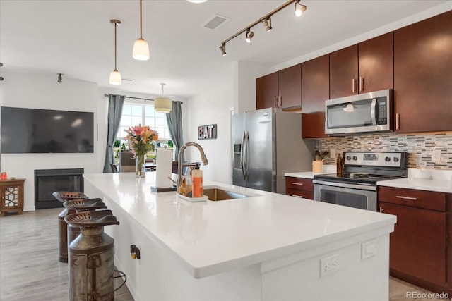 9227 Rolling Way Unit 201, Parker, CO 80134 - kitchen with stainless steel appliances, a sink, backsplash, a breakfast bar, and light countertops