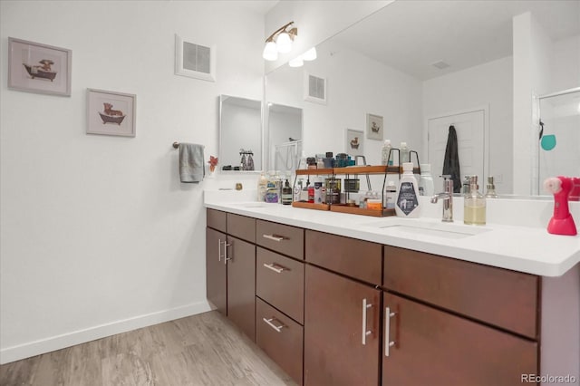 9227 Rolling Way Unit 201, Parker, CO 80134 - full bath featuring double vanity, wood finished floors, a shower with door, and baseboards