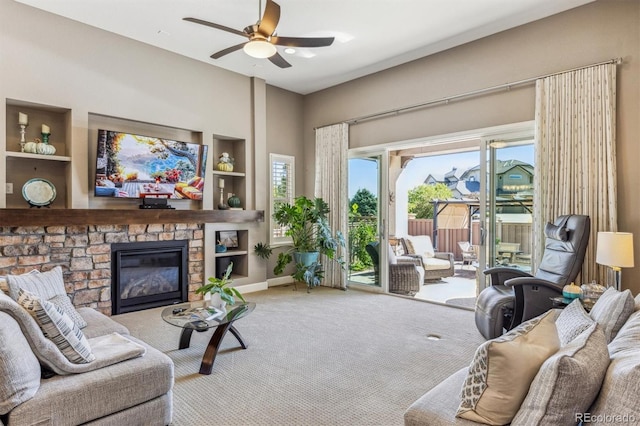 carpeted living room with ceiling fan and a fireplace