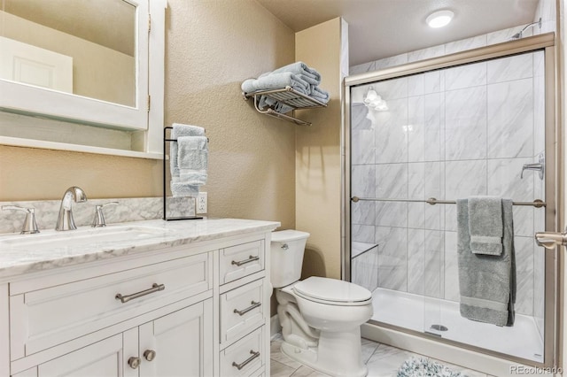 bathroom featuring toilet, vanity, and walk in shower