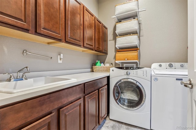 laundry room with cabinets, washer and clothes dryer, and sink