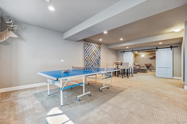 recreation room featuring a barn door and carpet floors