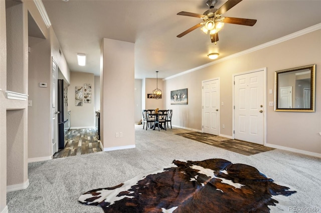 interior space featuring dark colored carpet, ceiling fan, and crown molding