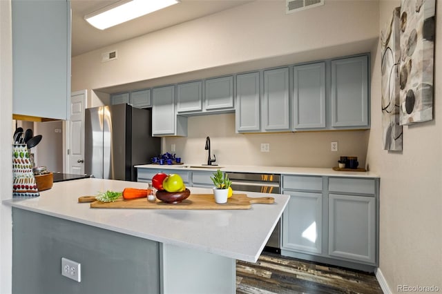 kitchen featuring gray cabinets, sink, kitchen peninsula, and stainless steel appliances