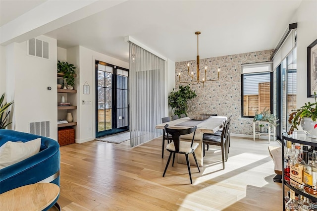 dining room with visible vents, light wood-style flooring, and wallpapered walls