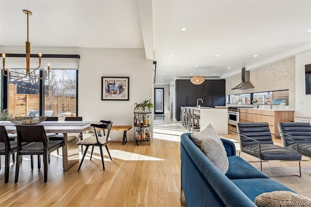 living area with light wood-style floors, a notable chandelier, and recessed lighting