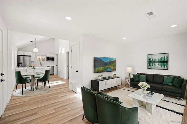 living room with lofted ceiling and light hardwood / wood-style flooring