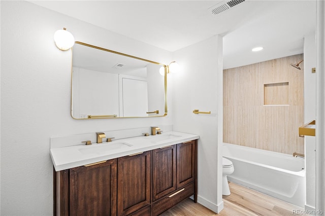 full bathroom with vanity, hardwood / wood-style flooring, toilet, and washtub / shower combination