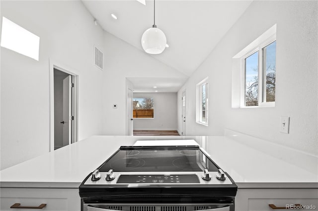 kitchen with decorative light fixtures, stainless steel electric stove, high vaulted ceiling, and kitchen peninsula