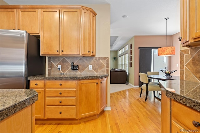 2488 Lake Vista Dr, Broomfield, CO 80023 - kitchen with freestanding refrigerator, tile counters, light wood-type flooring, and backsplash